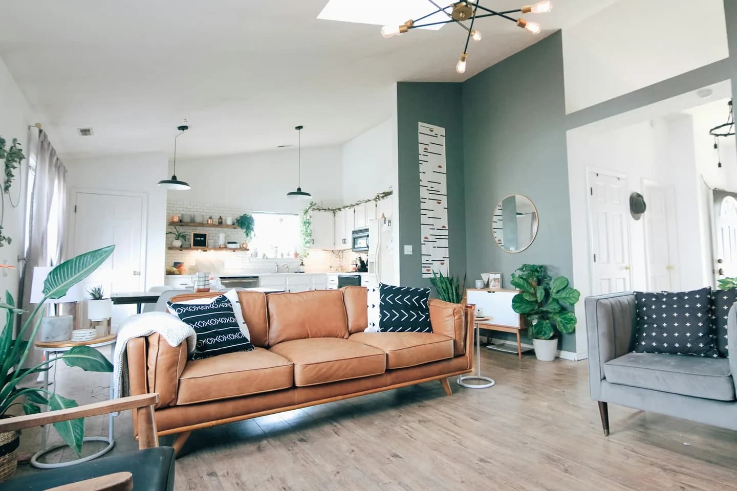 Illustrative home interior with a leather sofa, plants and warm wood furnishings